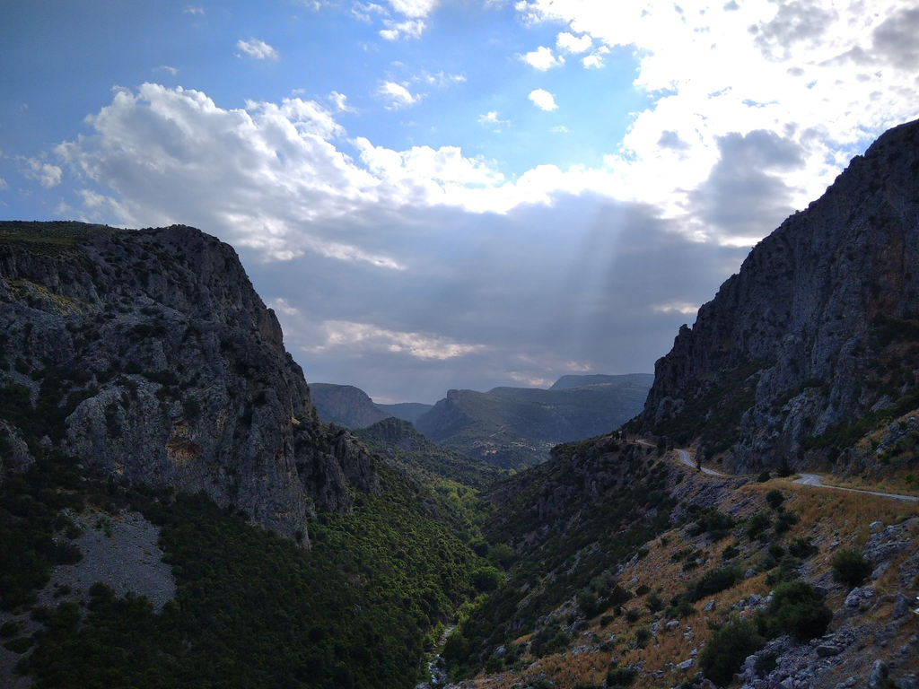Manikia, the view from the top with blue skies and sun-rays emerging from the clouds 